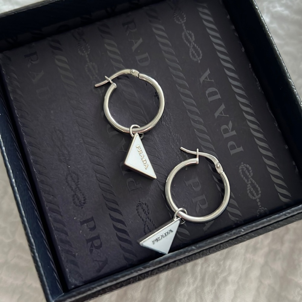 Prada earrings. White triangle with silver writing. Comes with box.